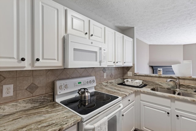 kitchen with sink, white cabinetry, a textured ceiling, white appliances, and backsplash