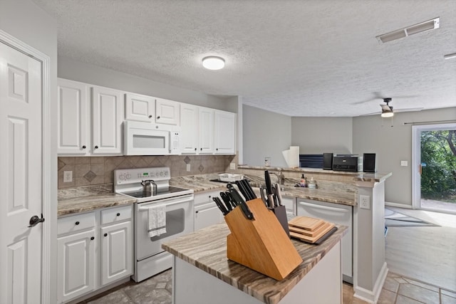 kitchen featuring a center island, white cabinets, and white appliances