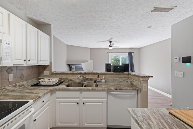 kitchen with white cabinetry, sink, white appliances, and kitchen peninsula