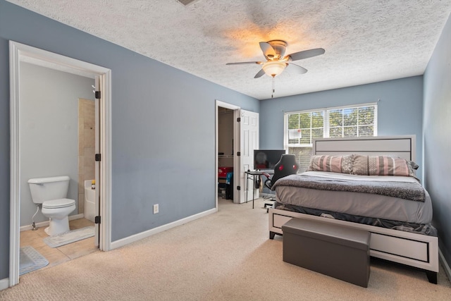 carpeted bedroom featuring ceiling fan, connected bathroom, and a textured ceiling