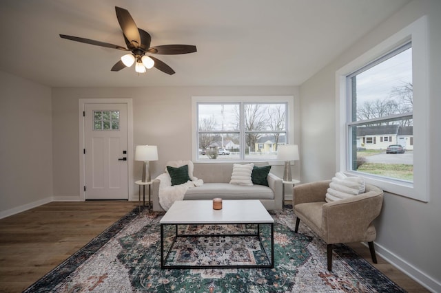 living room featuring plenty of natural light, dark wood-type flooring, and ceiling fan