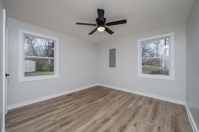 spare room featuring electric panel, ceiling fan, and light hardwood / wood-style floors