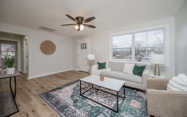 living room featuring light hardwood / wood-style flooring and ceiling fan