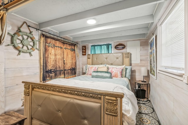 bedroom featuring beamed ceiling and wood walls