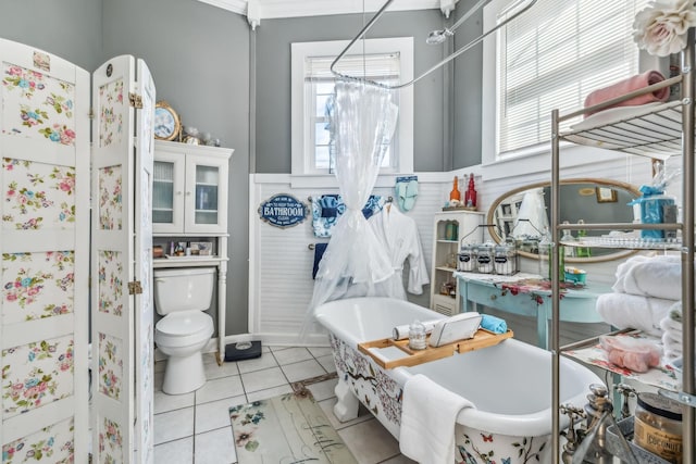 bathroom featuring a tub to relax in, tile patterned floors, and toilet