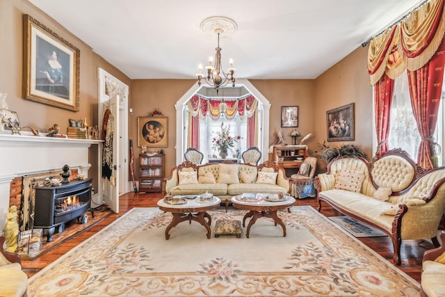 living room with a chandelier, hardwood / wood-style floors, and a wood stove