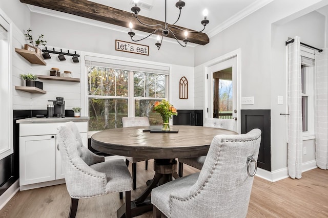 dining room with ornamental molding, beamed ceiling, light hardwood / wood-style floors, and an inviting chandelier