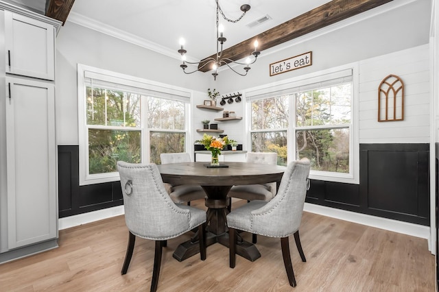 dining area featuring a chandelier, light wood-type flooring, and ornamental molding