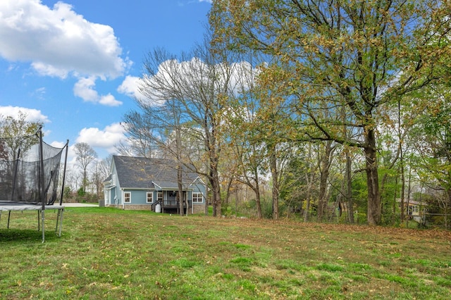 view of yard with a wooden deck and a trampoline