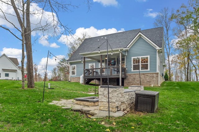 rear view of property with a lawn, ceiling fan, and a deck