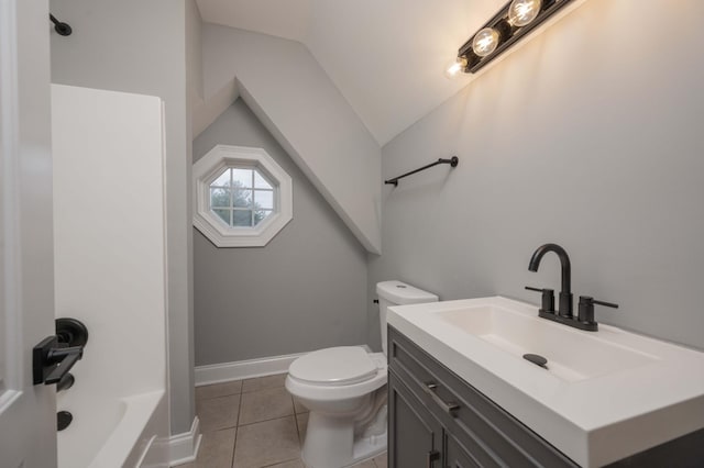 bathroom with tile patterned flooring, vanity, toilet, and lofted ceiling