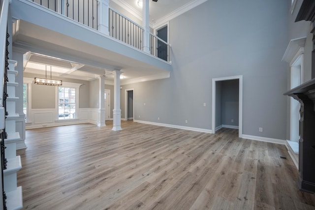 unfurnished living room with ornate columns, crown molding, light hardwood / wood-style floors, and coffered ceiling