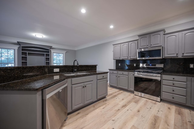 kitchen featuring gray cabinetry, sink, dark stone countertops, and stainless steel appliances