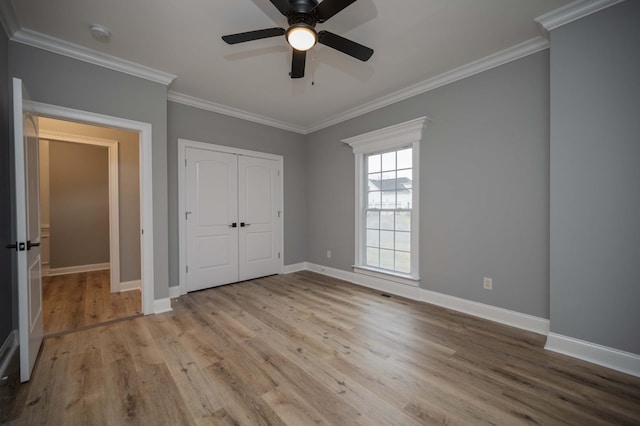 unfurnished bedroom featuring light wood-type flooring, a closet, ceiling fan, and ornamental molding