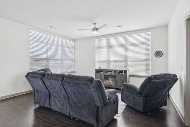 living room with ceiling fan and dark wood-type flooring