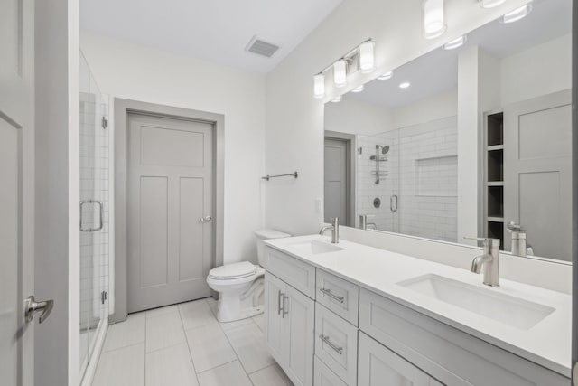 bathroom with tile patterned floors, vanity, toilet, and a shower with shower door