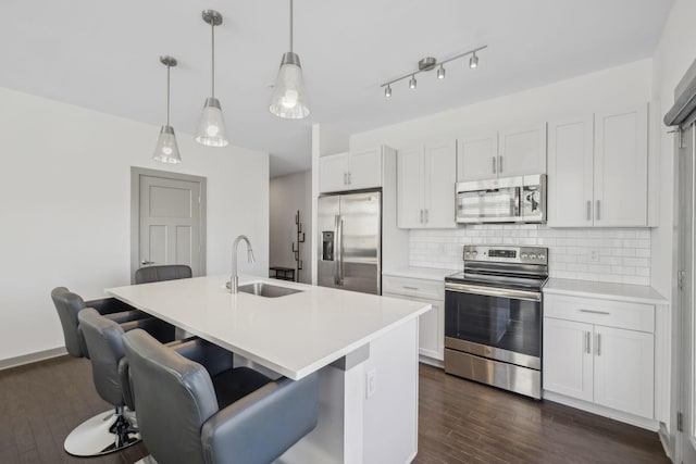 kitchen featuring decorative backsplash, appliances with stainless steel finishes, pendant lighting, and sink