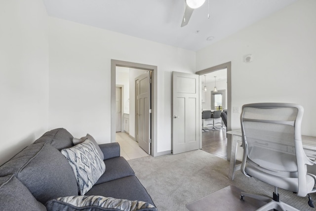 home office with ceiling fan and light carpet