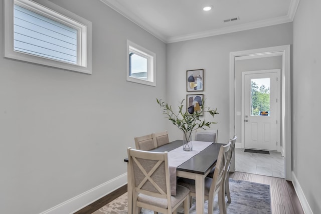 dining space featuring plenty of natural light, crown molding, and dark wood-type flooring