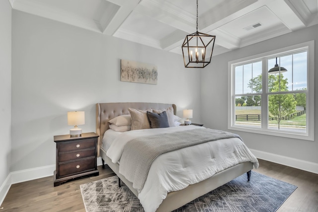 bedroom with beamed ceiling, hardwood / wood-style floors, a notable chandelier, and coffered ceiling