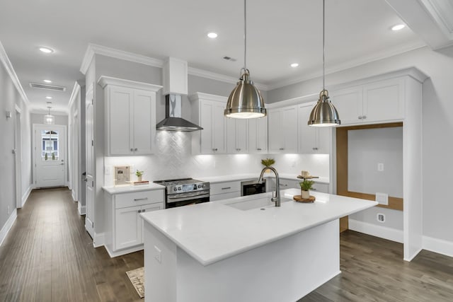 kitchen featuring stainless steel electric range, white cabinetry, a kitchen island with sink, and decorative light fixtures