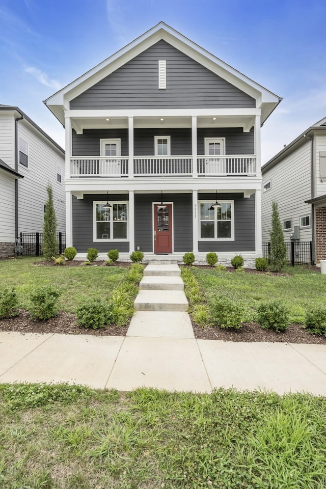 view of front of house with a front yard, a porch, and a balcony