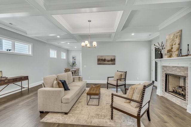 living room featuring coffered ceiling, beamed ceiling, a fireplace, hardwood / wood-style floors, and a chandelier