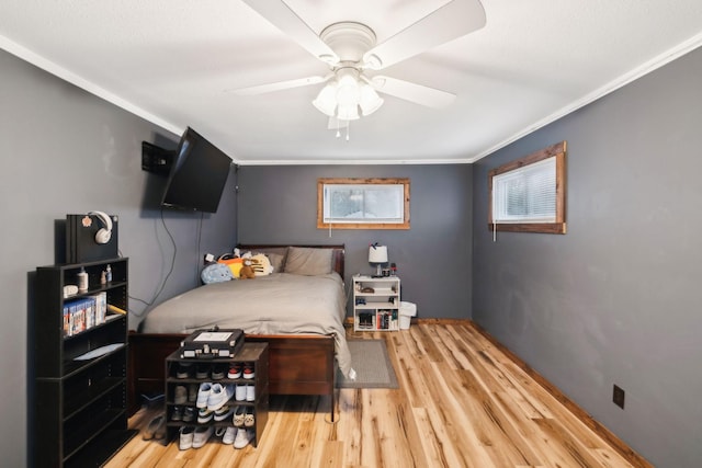 bedroom with ceiling fan, hardwood / wood-style floors, and crown molding