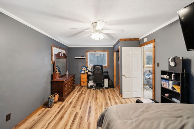 bedroom with a textured ceiling, ceiling fan, light hardwood / wood-style floors, and crown molding