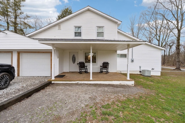 view of front of property with central air condition unit, a front yard, a porch, and a garage