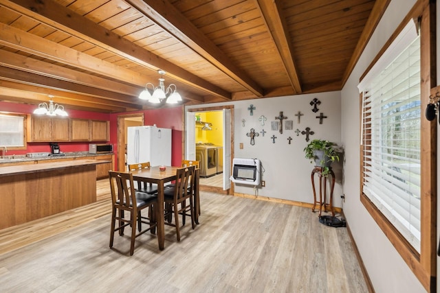 dining room with beamed ceiling, a notable chandelier, washing machine and clothes dryer, and heating unit