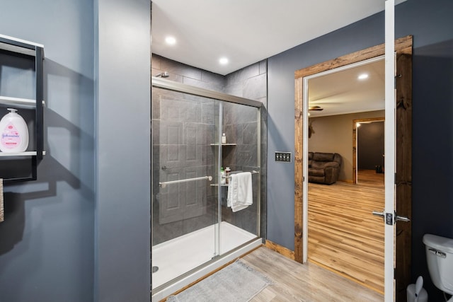 bathroom featuring wood-type flooring, toilet, and walk in shower