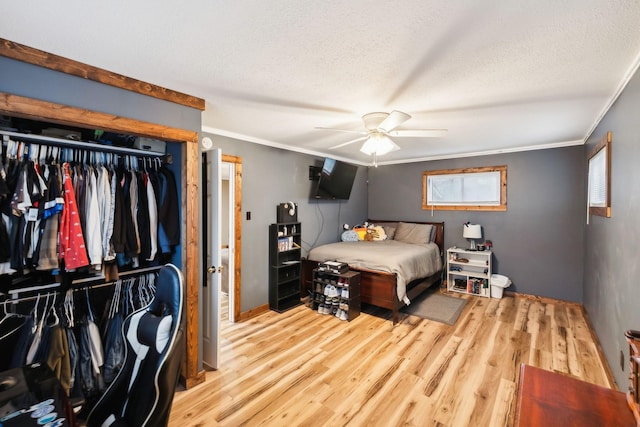 bedroom with ceiling fan, light hardwood / wood-style flooring, a textured ceiling, and ornamental molding