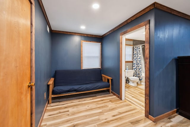 sitting room featuring wood-type flooring and crown molding