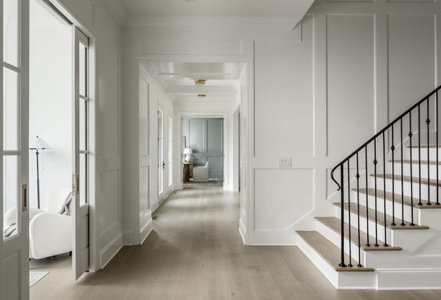 corridor with light hardwood / wood-style flooring and crown molding