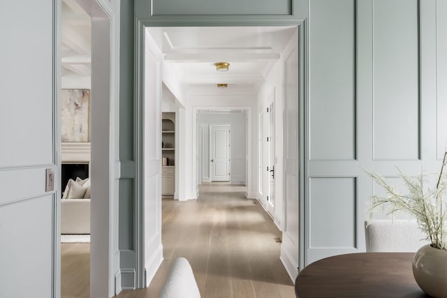 corridor featuring hardwood / wood-style floors and beamed ceiling