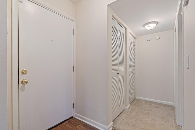 hall with baseboards and carpet