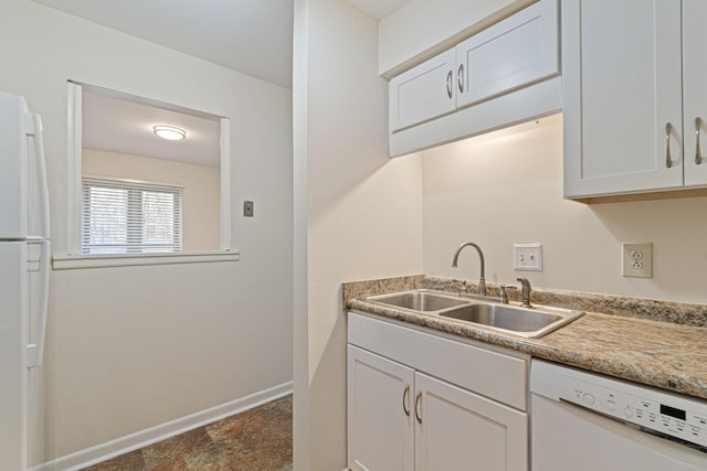 kitchen with white cabinets, white appliances, baseboards, and a sink