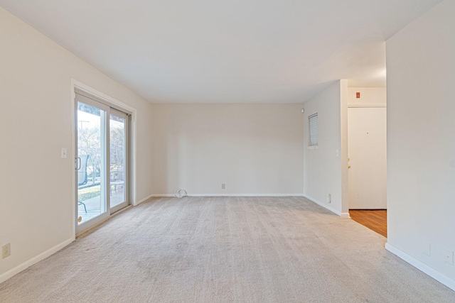 unfurnished room with light colored carpet and baseboards