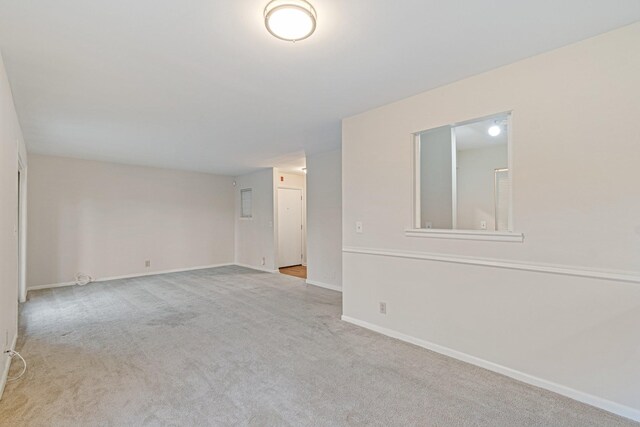 carpeted empty room featuring baseboards