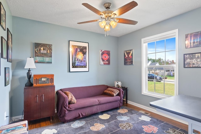 interior space featuring dark hardwood / wood-style floors, ceiling fan, and a textured ceiling