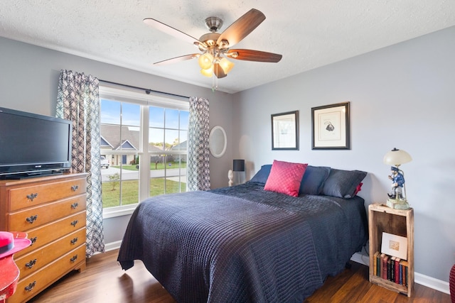 bedroom featuring a textured ceiling, ceiling fan, and dark wood-type flooring