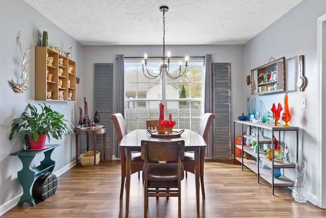 dining room with wood-type flooring, a textured ceiling, and a chandelier