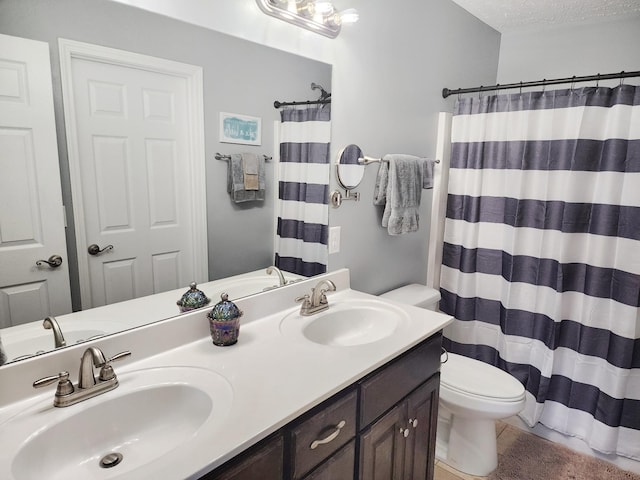 bathroom featuring vanity, a textured ceiling, toilet, and curtained shower