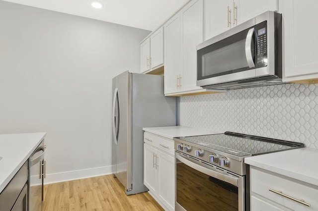 kitchen featuring white cabinetry, tasteful backsplash, stainless steel appliances, and light wood-type flooring