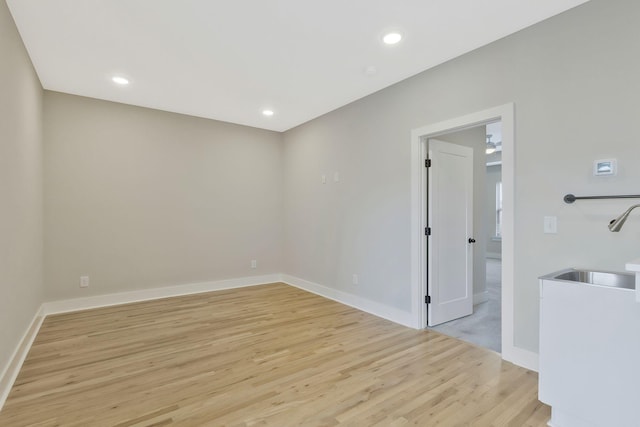 spare room with sink and light hardwood / wood-style floors