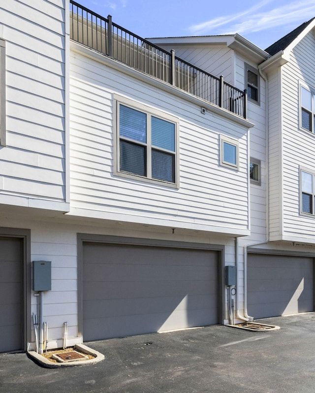 view of side of property with a garage and a balcony