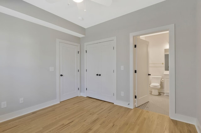 unfurnished bedroom featuring ensuite bathroom, a closet, ceiling fan, and light hardwood / wood-style floors