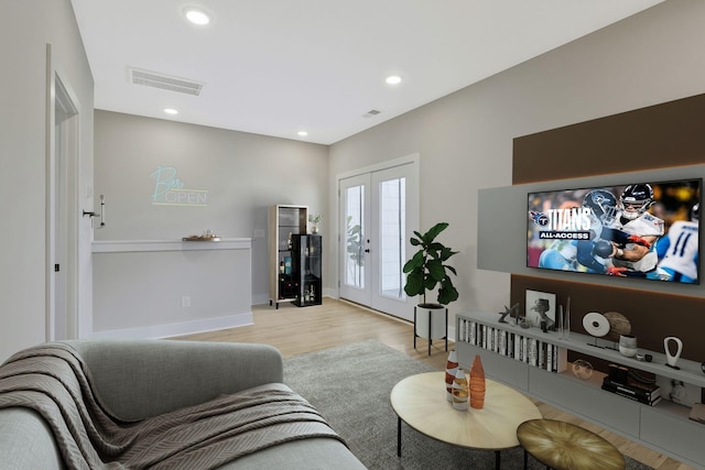 living room with french doors and light wood-type flooring