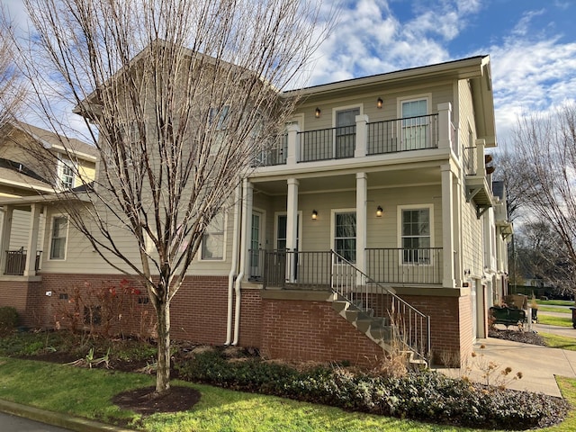 front facade featuring covered porch, a garage, and a balcony